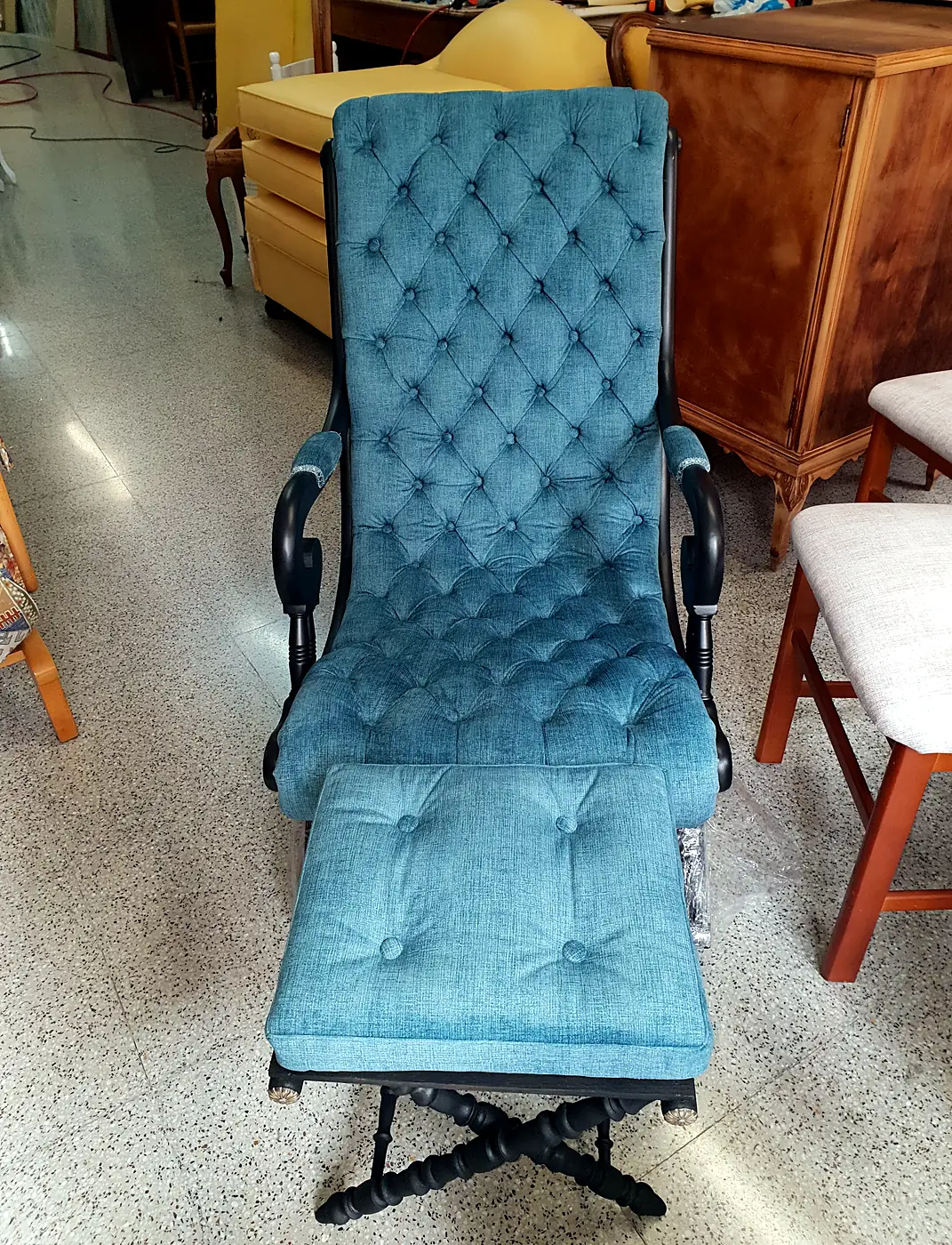 Mecedora con reposapiés tapizada en terciopelo azul con capitoné