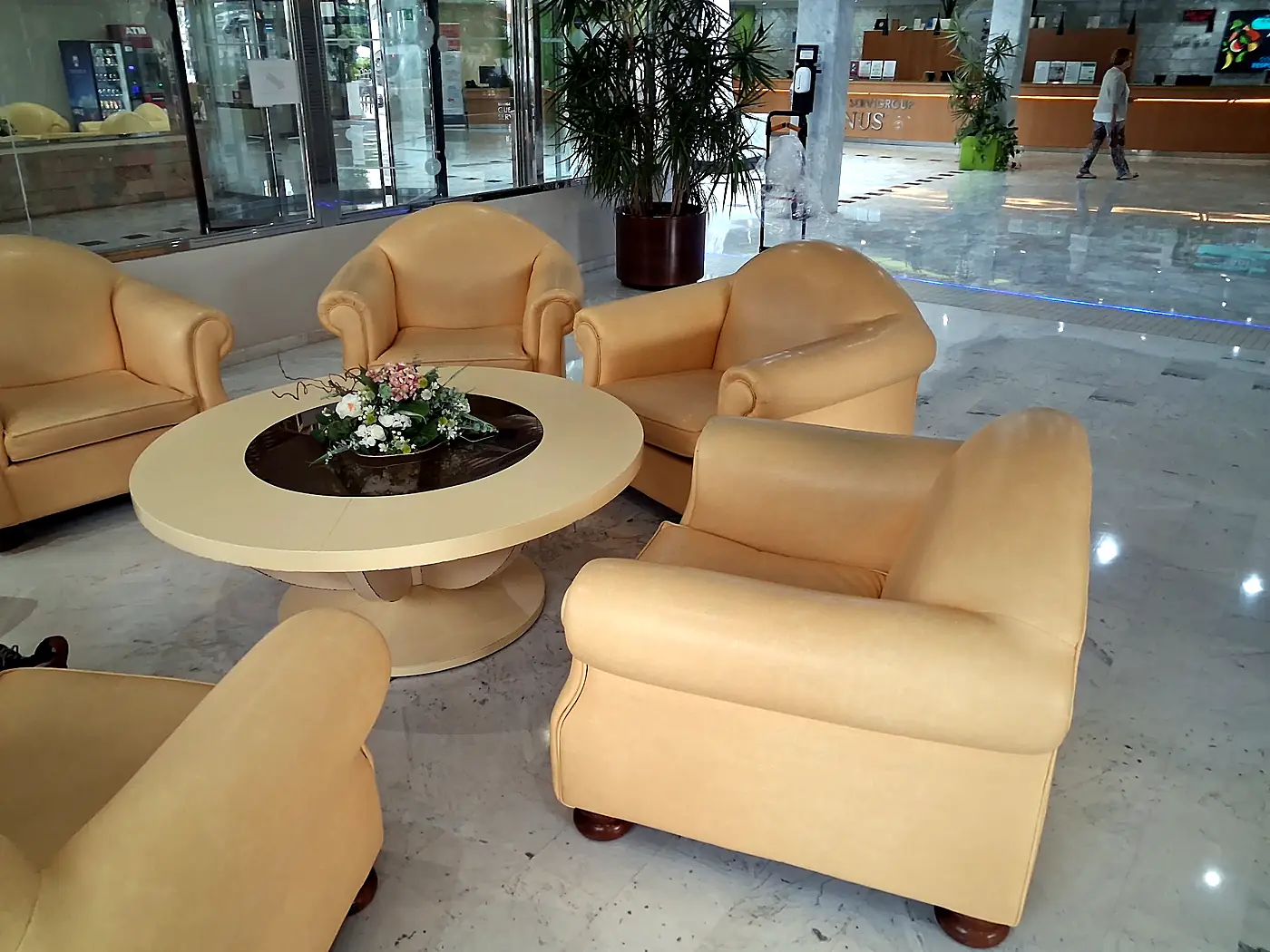 Butacas tapizadas en tono arena alrededor de una mesa en un hotel