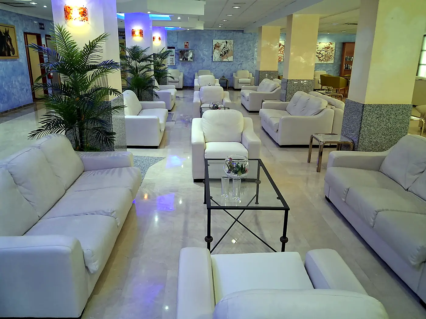 Sofás y butacas blancos en el vestíbulo de un hotel