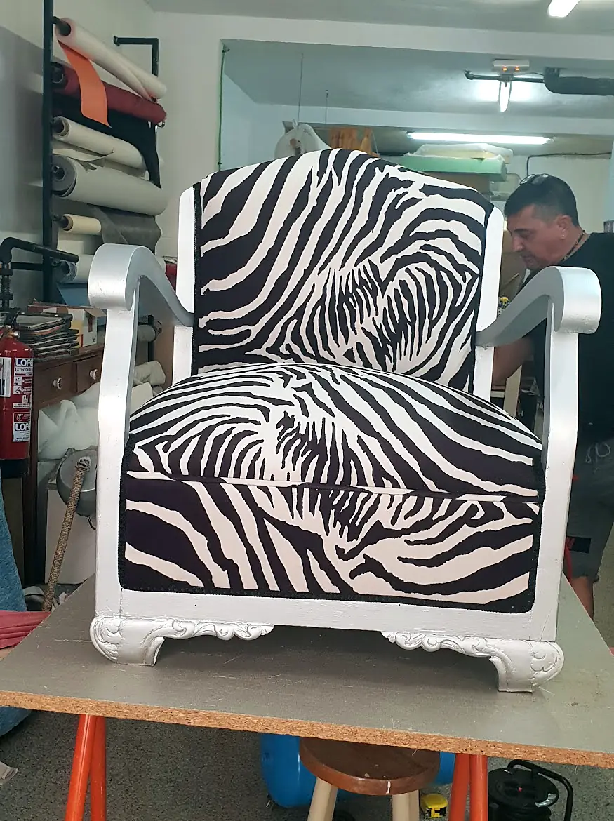White wooden armchair upholstered in zebra print