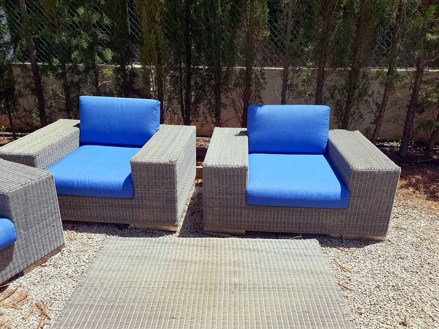 Outdoor wicker armchairs with blue cushions