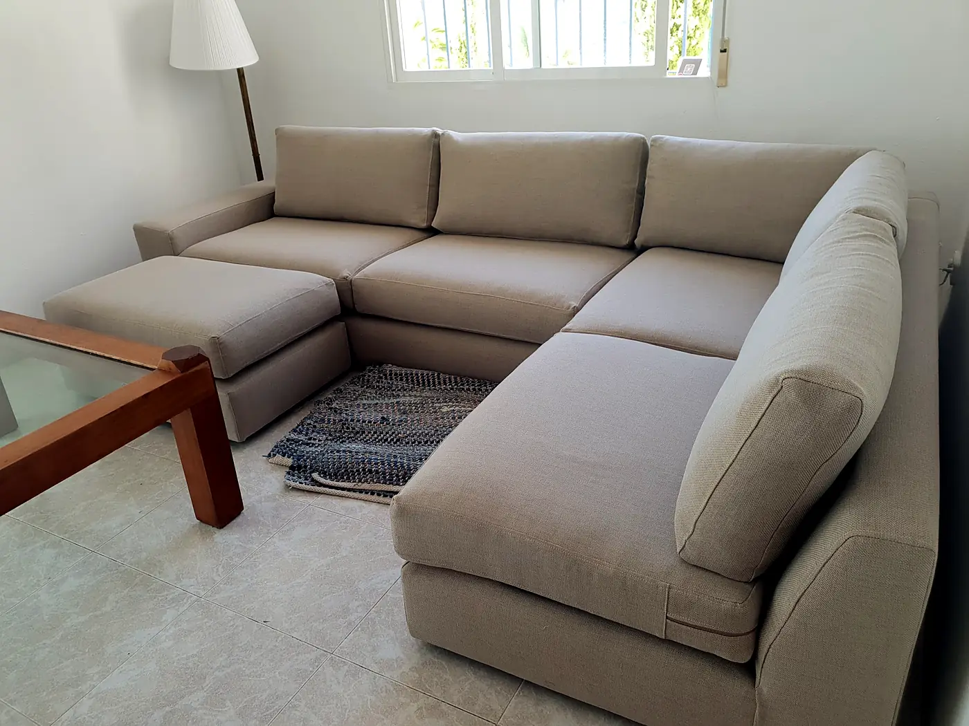 Corner sofa upholstered in beige fabric