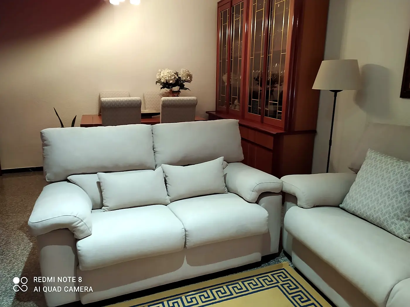 Sofa upholstered in light fabric with matching cushions in a living room